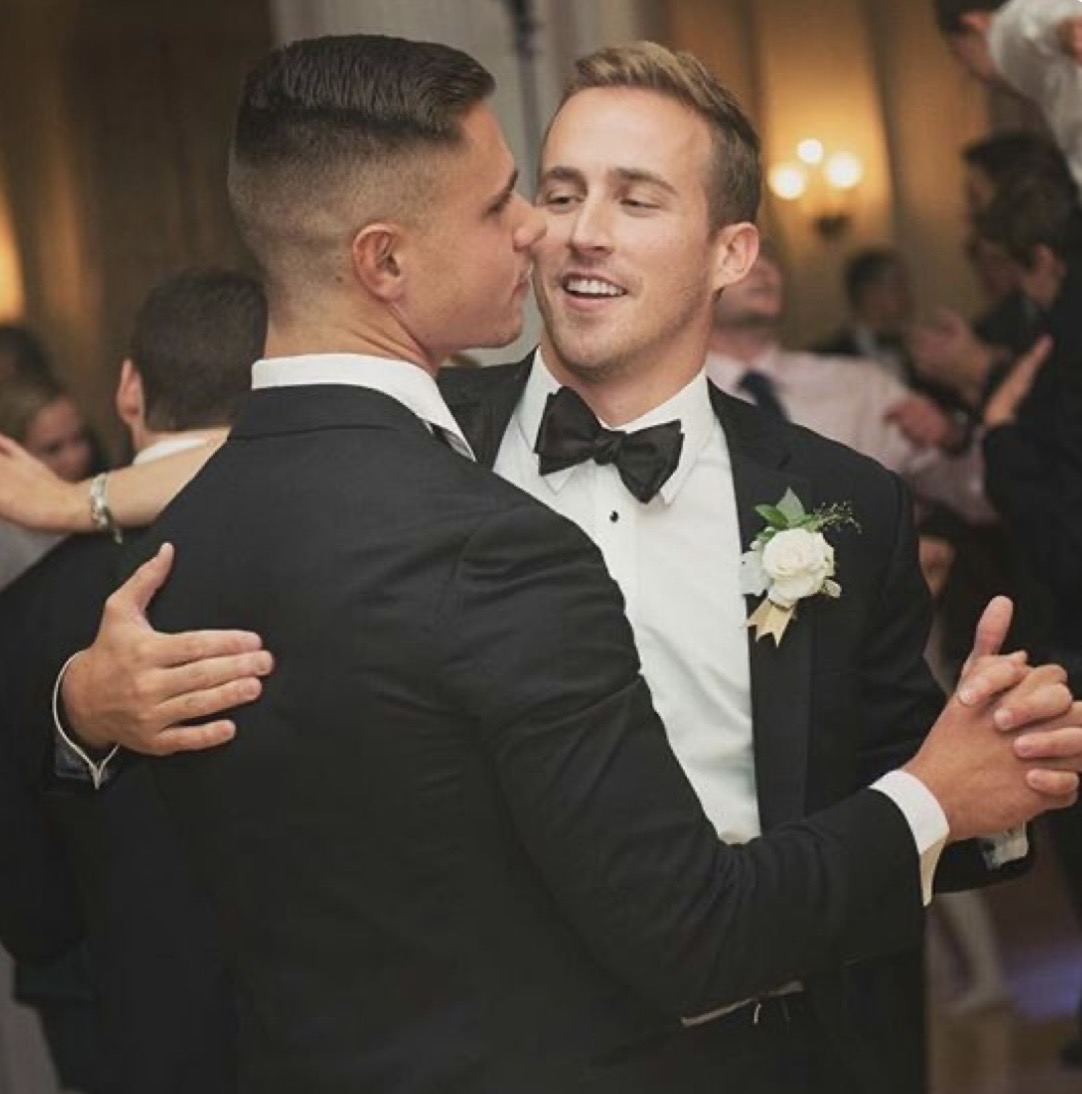 Two grooms sharing first dance at wedding reception