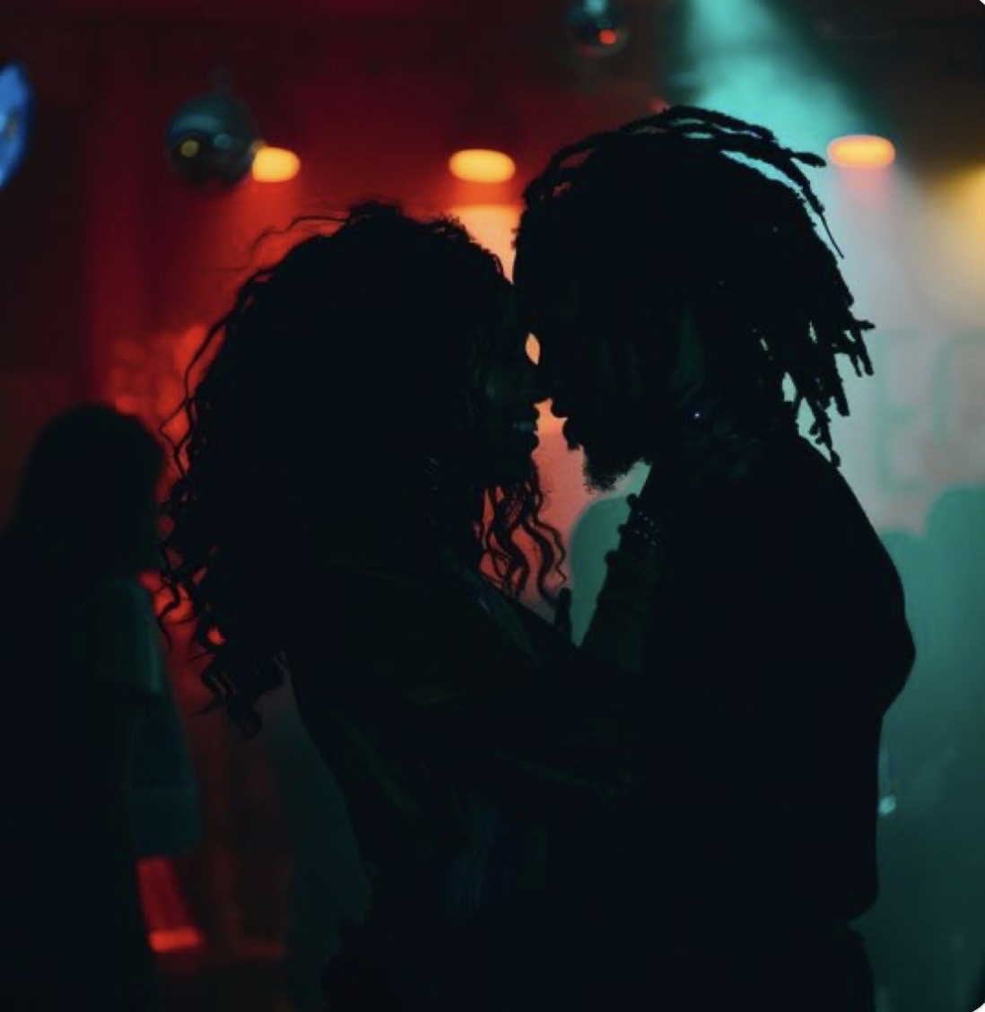 Silhouetted couple sharing an intimate dance under club lights